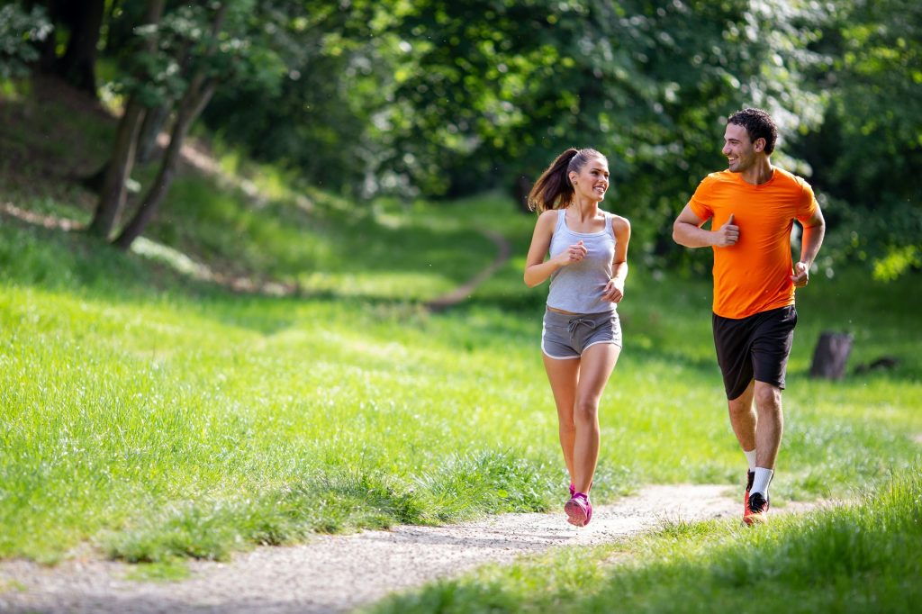 homem e mulher correm em parque