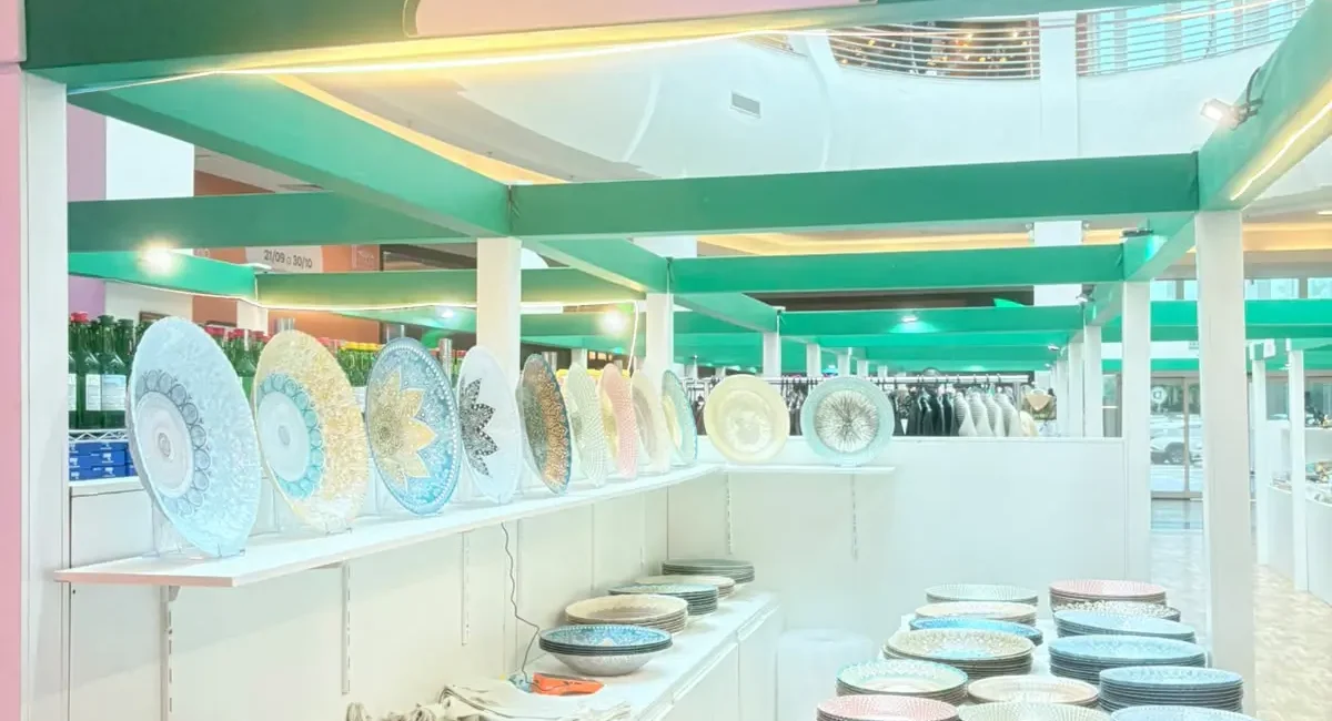 Estande da Turquia na Expo Arabia, no Mooca Plaza Shopping, com pratos decorados expostos na prateleira e pilhas de tigelas coloridas no balcão