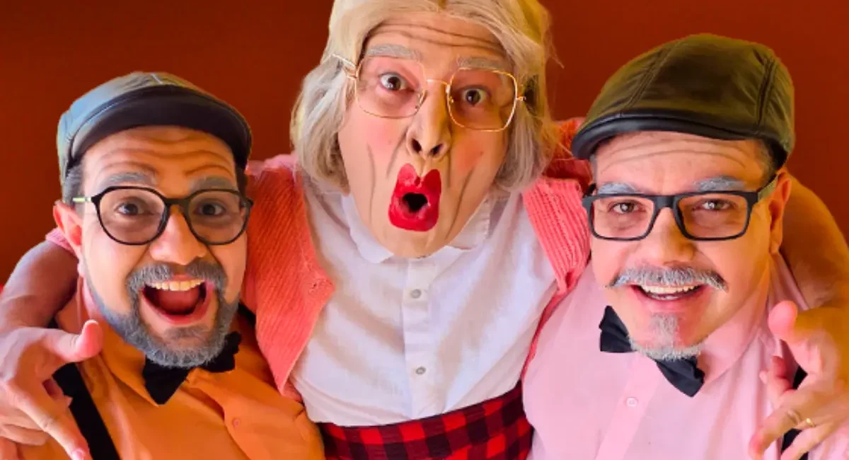 O grupo Músicos Geriatricus. Três homens caracterizados como idosos, usando óculos, perucas, boinas e maquiagem expressiva