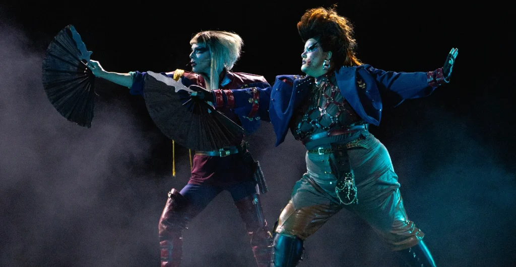 Cena de "Macbeth", da Cia. Extemporânea. As drag queens xia Twister e Ginger Moon empunham leques como se fossem armas
