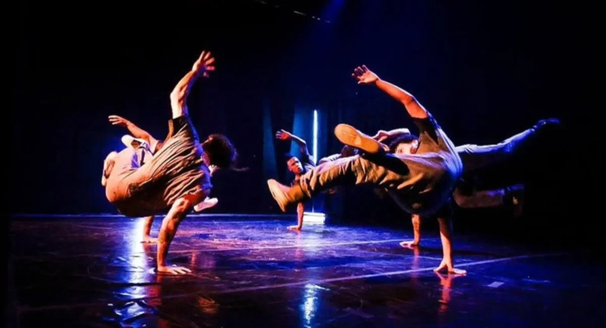 Apresentação de "Menino Assum Preto", do Flying Low. No palco, dois bailarinos fazem movimentos de break dance